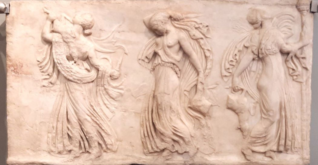 Menadi, donne che, prese dal furore sacro indotto da Dioniso (o altri dei), si abbandonano a danze orgiastiche sui monti. La scompostezza dei corpi e delle vesti, diviene spunto artistico per la più plastica rappresentazione delle forme femminili Menadi, donne che, prese dal furore sacro indotto da Dioniso (o altri dei), si abbandonano a danze orgiastiche sui monti. La scompostezza dei corpi e delle vesti, diviene spunto artistico per la più plastica rappresentazione delle forme femminili